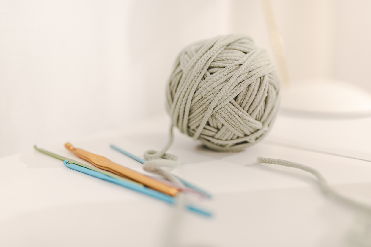 Threads for knitting arranged with crochets on table